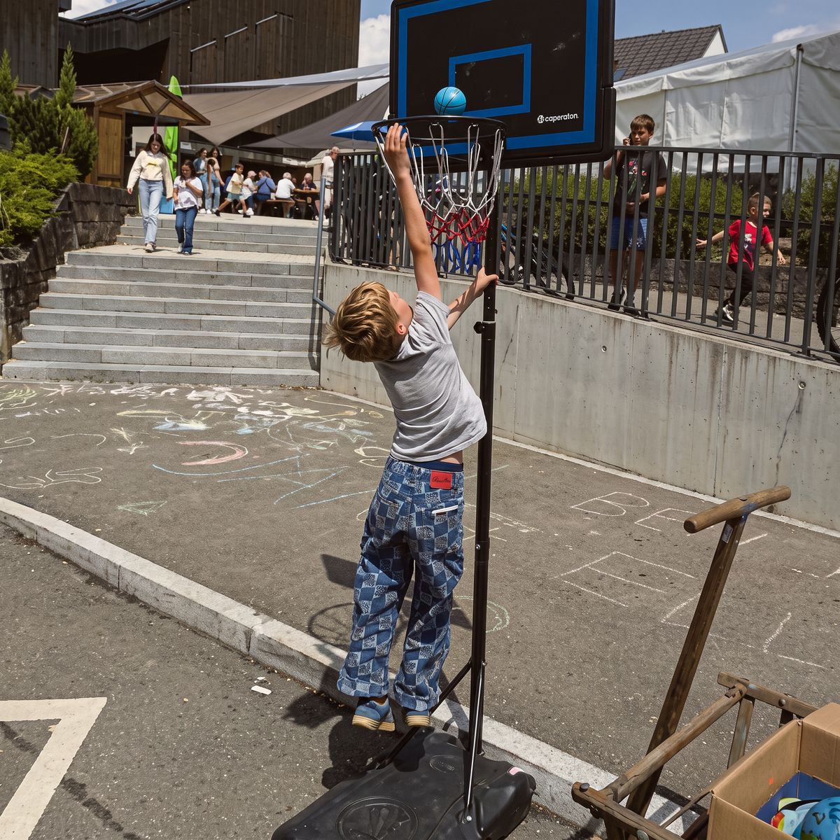 Ein Junge wirft beim Fleckenfest in Frickenhausen einen Ball in den Basketballkorb